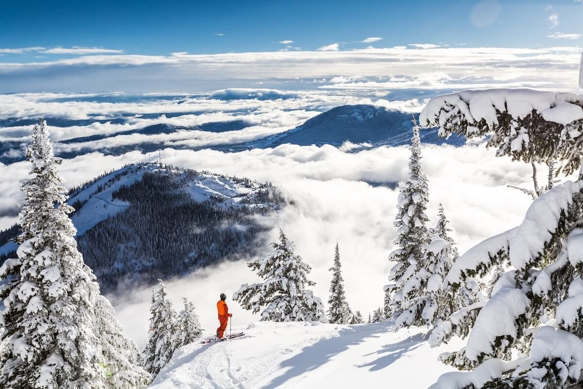  Le skieur regarde le terrain depuis Red Mountain 